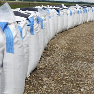 Sandbags lined up along a dirt road. 