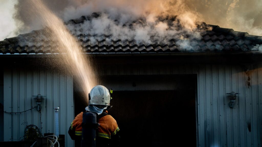 A person putting out a house fire